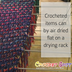 This is an example of a crochet shawl with fringe laid flat to dry.